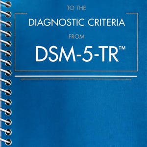 May include: A blue spiral-bound book titled Desk Reference to the Diagnostic Criteria from DSM-5-TR. The cover features white text and thin white horizontal lines, with a white metal coil binding along the left side of the rectangular reference guide.