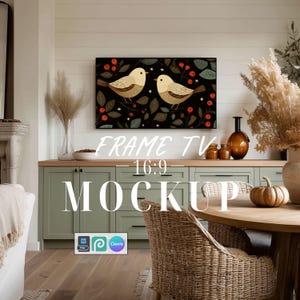 May include: A digital television screen displaying a graphic illustration of two beige birds perched among dark leaves and red berries. The screen is mounted on a white wall above sage green cabinets. The text FRAME TV 16:9 MOCKUP is overlaid.