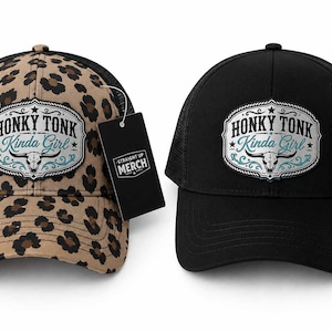 May include: Two trucker hats, one with a tan and black leopard print and one solid black. Both feature a central patch with a steer skull graphic and the text "HONKY TONK Kinda Girl" in black and teal. Each hat includes a black rectangular hang tag.