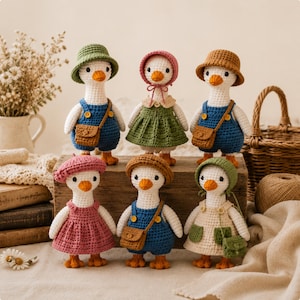 Könnte beinhalten: Sechs gehäkelte Gänsepuppen mit weißen Körpern und orangefarbenen Schnäbeln. Die Puppen tragen verschiedene Outfits, darunter blaue Latzhosen mit braunen Umhängetaschen, ein grünes Kleid, ein rosa Kleid, ein cremefarbenes Kleid mit grünen Taschen und Hüte.