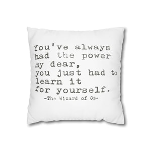 Puede incluir: Cojín cuadrado blanco con la cita "You've always had the power my dear, you just had to learn it for yourself." de El Mago de Oz, impresa en texto gris.