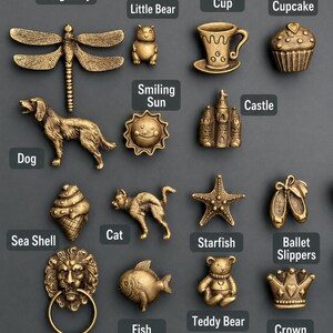 Pu&ograve; includere: Una collezione di pomelli decorativi in metallo color ottone antico con varie forme, tra cui una libellula, un cane, una conchiglia, una testa di leone con anello, un orsetto, un sole sorridente, un gatto, un pesce, una tazzina da caff&egrave;, un castello, una stella marina, un orsacchiotto, un cupcake, scarpette da danza e una corona.
