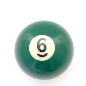 May include: A smooth, spherical billiard ball with a glossy dark green finish. Centered on the ball is a white circular inlay featuring the number 6 printed in a bold, black sans-serif font. The surface reflects light, highlighting its round shape.