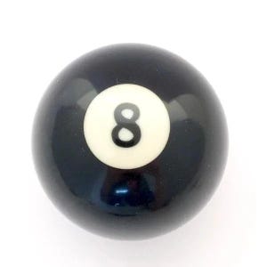 May include: A smooth, spherical billiard ball with a glossy black finish. Centered on the ball is a white circular inlay featuring the number eight printed in a bold, black sans-serif font. The object has a reflective surface and uniform shape.