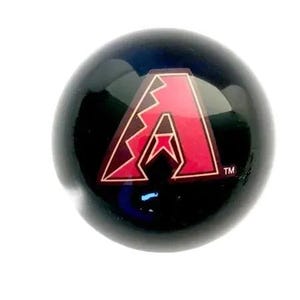 May include: A smooth, spherical black object featuring a prominent red and dark red letter A logo with a jagged, lightning-bolt-style design element on the left side. The logo includes a small trademark symbol in the bottom right corner.