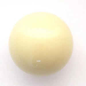 May include: A smooth, solid, cream-colored sphere with a glossy finish. The object is perfectly round and uniform in its light off-white hue, reflecting light evenly across its curved surface, creating a bright highlight near the top center.