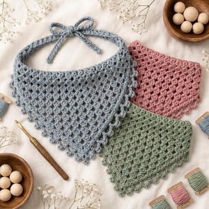 May include: Three triangular crochet bandanas in dusty blue, dusty rose, and sage green. Each piece features a textured cluster stitch pattern with a scalloped edge and tie-back strings. The set includes wooden beads and yarn spools.