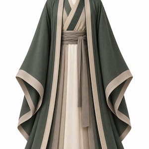 Puede incluir: Una túnica superpuesta con una capa exterior de color verde bosque oscuro, mangas anchas y ribetes beige, sobre una prenda interior color crema. El conjunto incluye un fajín ancho envolvente en un tono marrón apagado y estructurado.