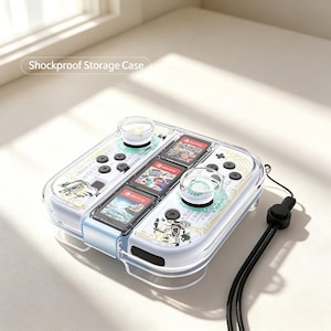 May include: A clear, shockproof storage case for a gaming console controller, featuring white and gold patterned accents, two analog stick covers, and three game card slots. The case includes a black wrist strap and displays the text Shockproof Storage Case.