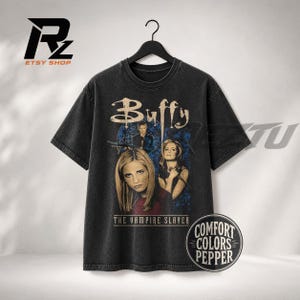 Puede incluir: Una camiseta de manga corta gris carbón con un estampado gráfico de Buffy Cazavampiros. El diseño incluye el texto Buffy y The Vampire Slayer con imágenes del personaje principal. Una insignia circular dice Comfort Colors Pepper.