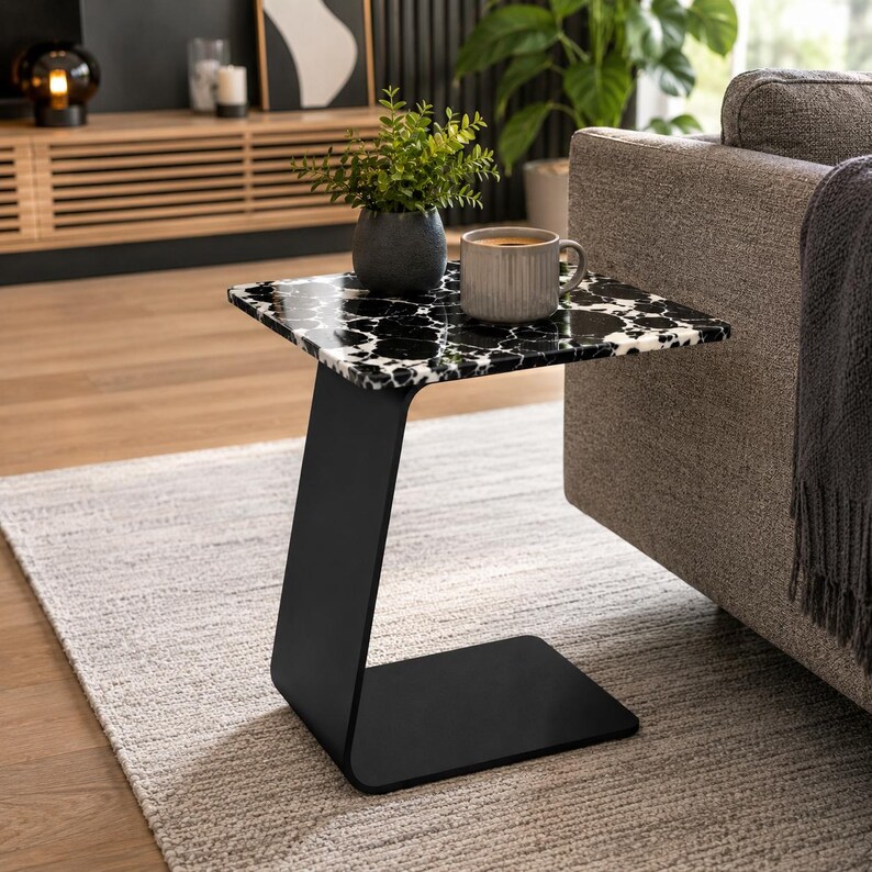 Close-up of polished natural marble tabletop showcasing unique black and white veining, handcrafted luxury marble side table, premium stone furniture, elegant coffee table surface with natural marble texture.