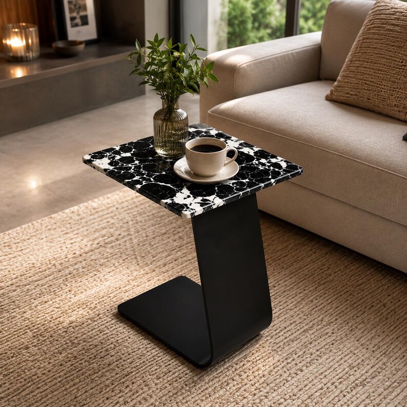 Top view of handcrafted marble side table with polished natural marble surface, coffee cup and decorative plant, luxury living room furniture, modern marble coffee table, elegant sofa end table for contemporary homes.