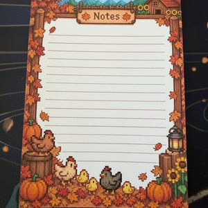 Peut inclure: Un bloc-notes rectangulaire avec des lignes horizontales et un thème de ferme automnale en pixel art. La bordure présente des feuilles d'érable orange, des citrouilles, des tournesols, une grange, une lanterne, des poules et des poussins.