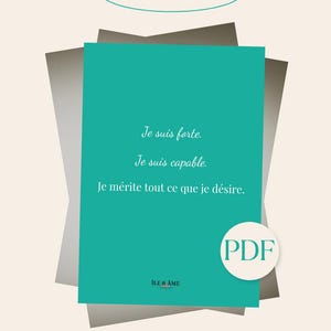 Peut inclure: Une carte d'affirmation rectangulaire turquoise avec le texte français : Je suis forte. Je suis capable. Je mérite tout ce que je désire. La carte inclut le nom de marque ILE & AME, une icône PDF et le texte CARTE AFFIRMATIONS en haut.