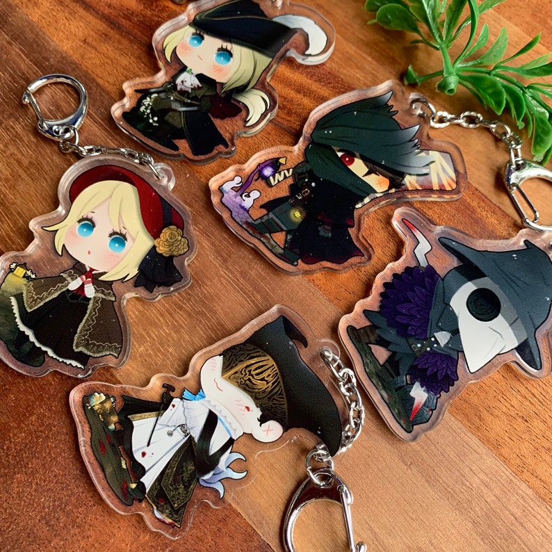 K&ouml;nnte beinhalten: F&uuml;nf bunte Anime-Charakter-Schl&uuml;sselanh&auml;nger mit Glitzerakzenten. Jeder Schl&uuml;sselanh&auml;nger zeigt einen anderen Charakter mit einem einzigartigen Design und einer silbernen Kette.