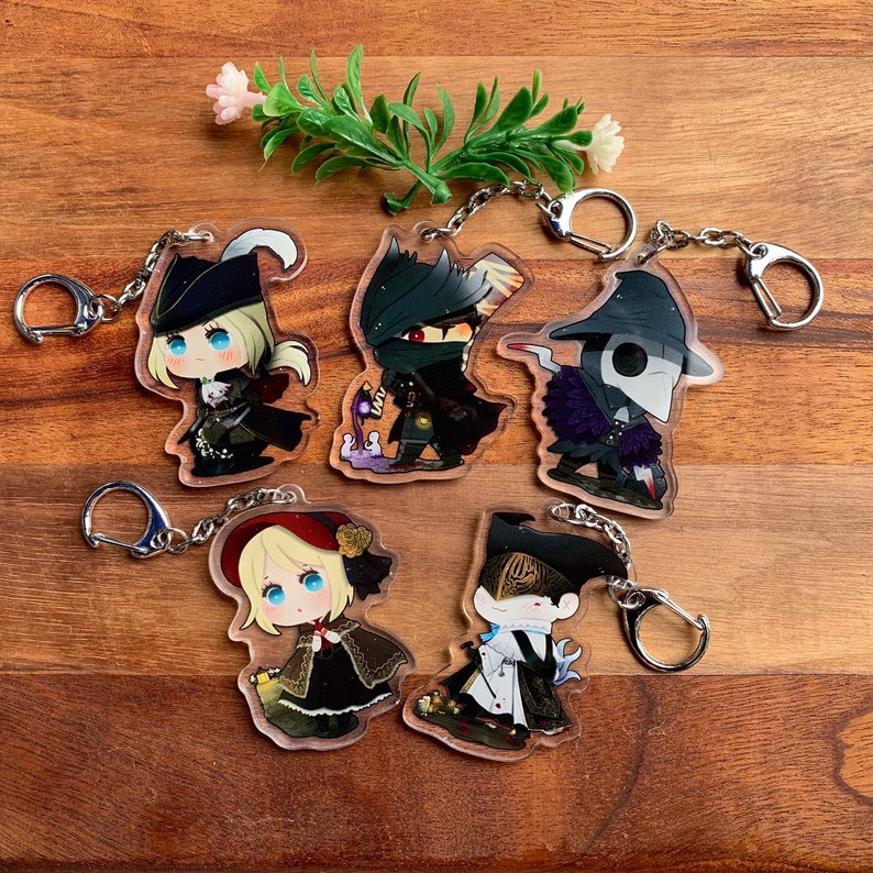K&ouml;nnte beinhalten: Satz mit f&uuml;nf Anime-Charakter-Schl&uuml;sselanh&auml;ngern. Jeder Schl&uuml;sselanh&auml;nger zeigt einen anderen Charakter mit einem einzigartigen Design und Farbschema. Die Charaktere sind im Chibi-Stil dargestellt, mit gro&szlig;en K&ouml;pfen und kleinen K&ouml;rpern. Die Schl&uuml;sselanh&auml;nger sind aus klarem Acryl gefertigt und haben silberne Metallringe.