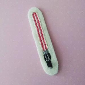 May include: A white felt patch with an embroidered red and white lightsaber. The lightsaber has a black handle with silver details.