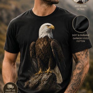 May include: A black short-sleeve t-shirt featuring a detailed graphic of a bald eagle perched on a rock. The design includes the text Wildlife Collection, Artwork Detail, and Soft & Durable Garment-Dyed Cotton, with additional icons and text.