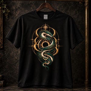 Könnte beinhalten: Ein schwarzes Kurzarm-T-Shirt mit einer zentralen Grafik einer gewundenen grünen und goldenen Schlange, die mit geometrischen goldenen Kreisen und Linien verflochten ist. Das Design enthält ein sternförmiges Element oben und ein Kreismuster.