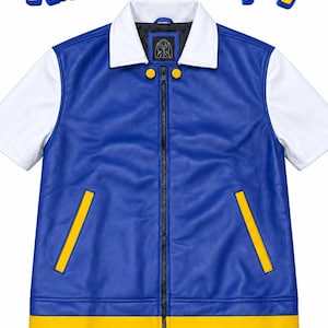 Könnte beinhalten: Eine blau-weiße Kurzarmjacke mit Reißverschluss, weißem Kragen, gelben Tascheneinfassungen und einem gelben Saum. Der Text Ash Ketchum Cosplay ist oben in gelben und blauen Buchstaben vor einem weißen Hintergrund abgebildet.