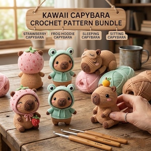 May include: A collection of six crocheted capybara figures featuring various accessories including strawberry hats, frog hoodies, and sleeping masks. The display includes a wooden sign labelled KAWAII CAPYBARA CROCHET PATTERN BUNDLE and three 3.5mm crochet hooks.