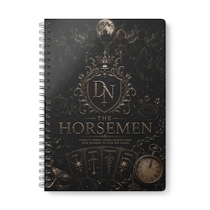 May include: A spiral-bound notebook with a black cover featuring gold-toned graphics. The cover displays the text "DN THE HORSEMEN" above four cards labelled "WAR," "FAMINE," "PESTILENCE," and "DEATH," along with a pocket watch and a full moon.