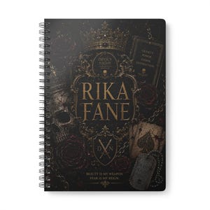 May include: A black spiral-bound notebook featuring gold-toned gothic illustrations including a crown, skull, roses, playing cards, and dog tags. The text reads RIKA FANE, DEVIL'S NIGHT, LOYALTY POWER CHAOS DESTRUCTION, and BEAUTY IS MY WEAPON, FEAR IS MY REIGN.