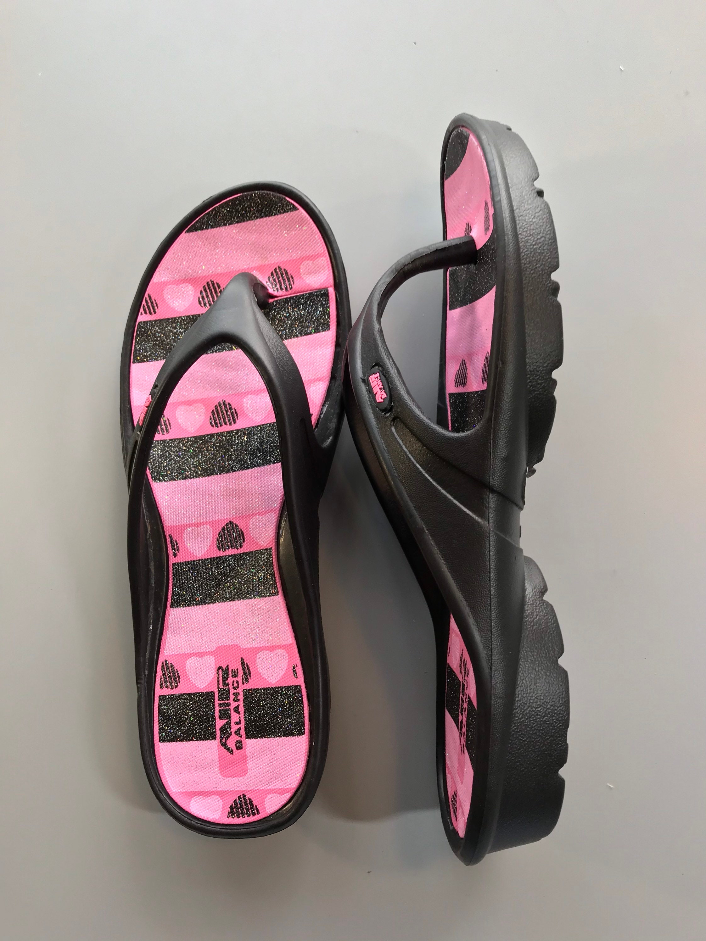 Gett Wett Flip Flops by Air Balance Women’s Black / Fuchsia Heart Stripe