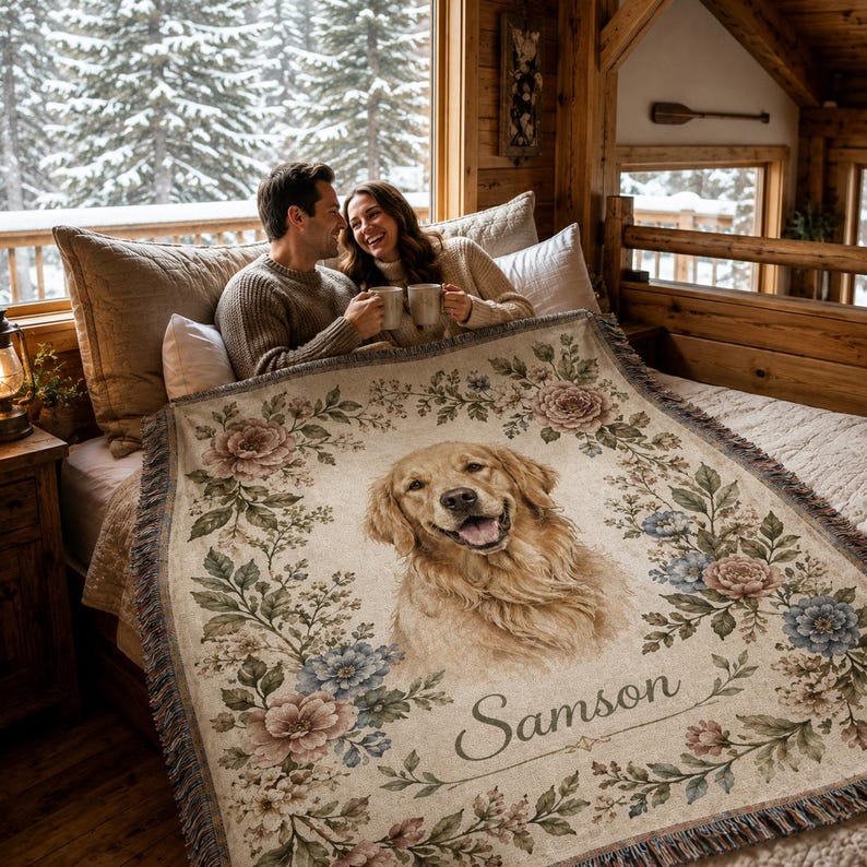 Couple using personalized dog woven blanket in cozy cabin bedroom, custom pet portrait throw with floral border.