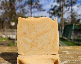 May include: A rectangular bar of soap with a light orange and cream marbled pattern. The soap has a smooth, matte texture with visible fine particles throughout the surface. It is stacked vertically, showing a solid, uniform light orange base.