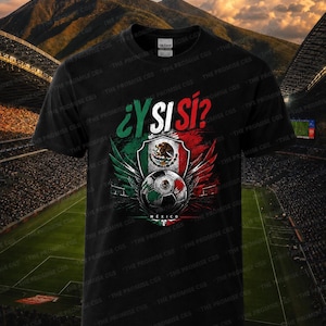 May include: A black short-sleeved t-shirt featuring a graphic print with the text ¿Y SI SÍ? above a shield displaying the Mexican flag, wings, and a soccer ball. The design incorporates green, white, and red colors, with the word MEXICO below the ball.