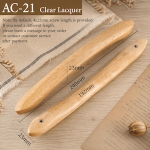 May include: Two light-coloured wooden cabinet handles with a clear lacquer finish. The longer handle measures 240mm in length and 23mm in width, while the shorter handle measures 192mm in length and 23mm in width. Both feature a single screw hole.