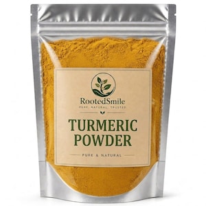 Puede incluir: Una bolsa plateada con cierre hermético llena de polvo de cúrcuma amarillo brillante. La etiqueta muestra un icono de planta, el texto RootedSmile, PURE. NATURAL. TRUSTED., TURMERIC POWDER y PURE & NATURAL en letras verde oscuro y negro sobre fondo beige.