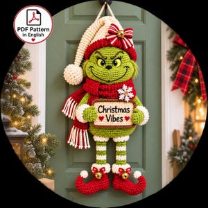 Peut inclure: Une décoration murale en crochet représentant un personnage vert portant un bonnet rouge et blanc avec un nœud, une écharpe rouge et des chaussures rouges recourbées avec des grelots dorés. Il tient un panneau indiquant Christmas Vibes.