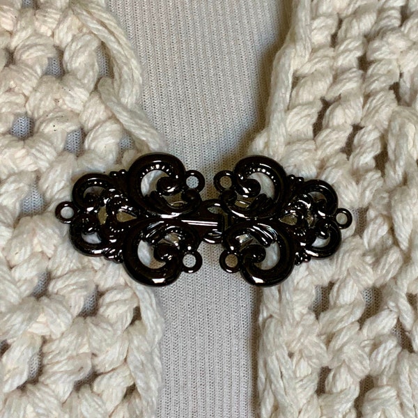 The mattie large black metal swirl sweater clip clasp.
