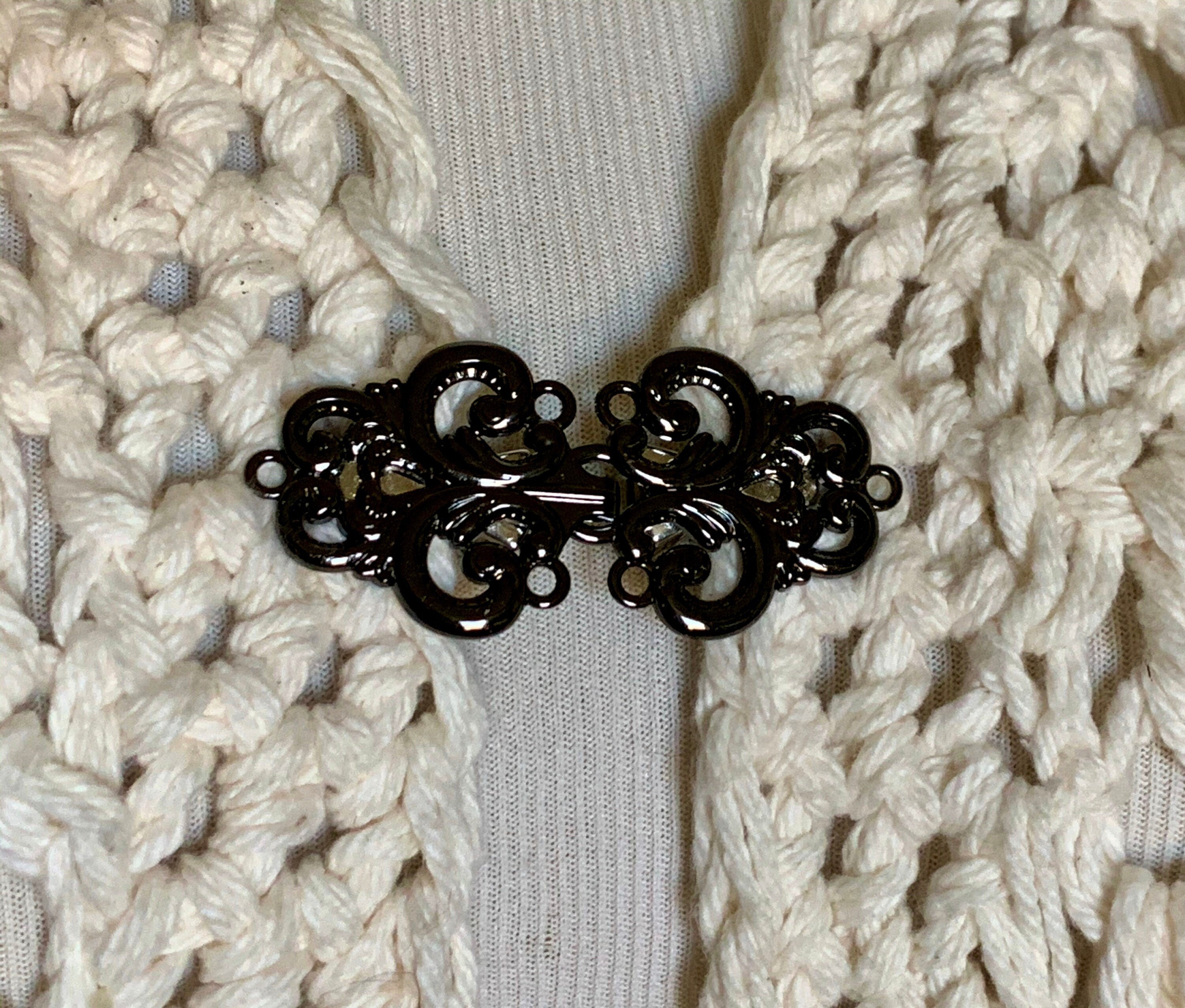 The mattie large black metal swirl sweater clip clasp.