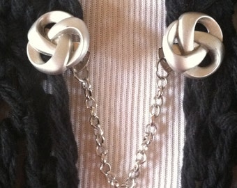 The mattie  brushed silver tone knot sweater clip is the modern way to wear an old favorite.