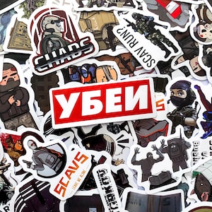 Op de afbeelding: Een verzameling diverse vinylstickers met verschillende militaire illustraties, personages in tactische uitrusting en tekst waaronder "CHAOS", "SCAV RUN?", "SCAVS" en het Cyrillische woord "УБЕЙ" in wit op een opvallende rode achtergrond.