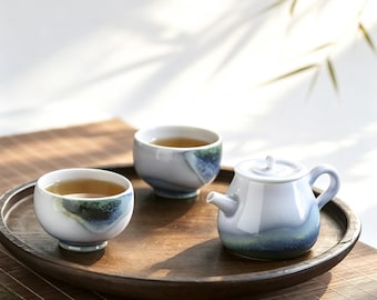 Handgemaakt theeservies van Jingdezhen keramiek met craqueléglazuur in een veranderende oven, bestaande uit een ronde theepot en kopjes.