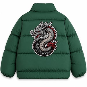 Op de afbeelding: Een donkergroene gewatteerde jas met een hoge kraag en horizontale stiksels. In het midden op de rug bevindt zich een grote, gedetailleerde grafische patch van een opgerolde draak met grijze schubben, rode accenten en scherpe lijnen.