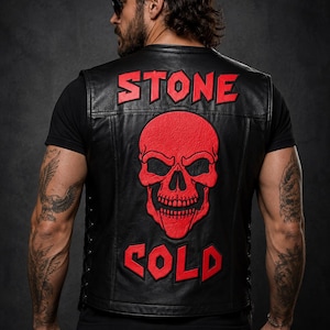 Peut inclure: Un gilet en cuir noir avec un grand écusson de crâne rouge dans le dos. Le mot STONE est brodé en rouge au-dessus du crâne, et le mot COLD est brodé en rouge en dessous. Le gilet présente des détails de laçage sur les côtés et une finition lisse.