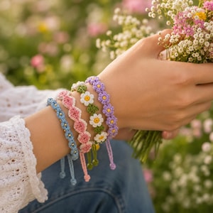 May include: Four handmade crochet bracelets featuring floral and geometric patterns in light blue, pink, green, and purple. Each bracelet is crafted with small thread loops and accented with tiny gold-colored beads, finished with adjustable tie closures.
