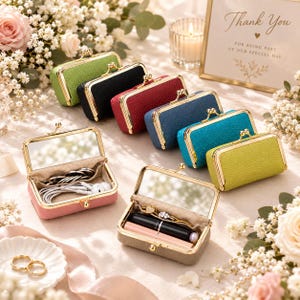 May include: A collection of rectangular, textured leather cases with gold-toned metal frames and kiss-lock closures. Two cases are open, revealing interior mirrors and compartments holding small items like earbuds, rings, and lipsticks.