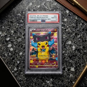 May include: A graded 2016 Japanese Pokemon trading card featuring Pikachu wearing a black and blue dragon poncho. The card is encased in a clear plastic slab with a label at the top reading 2016 P.M. JPN. XY PROMO PONCHO-WEAR.PIKACHU #207 GEM MT.