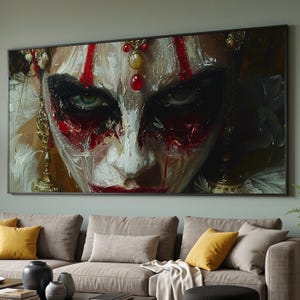 Op de afbeelding: Een rechthoekige wandkunstprint met een close-up olieverfschilderij van een gezicht met zware zwarte en rode make-up, gouden bungelende oorbellen en een voorhoofdsornament met rode en gele edelstenen in een dikke, textuurrijke impasto-stijl.
