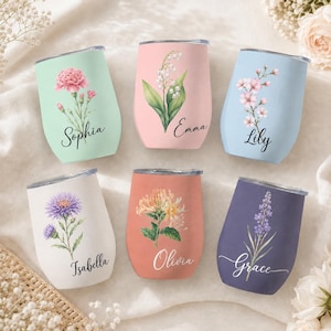 Op de afbeelding: Zes steelvrije bekers met deksels, elk met een unieke pastelkleur, een bloemenillustratie en een gepersonaliseerde naam in zwart schrift. De kleuren zijn mintgroen, zachtroze, lichtblauw, crème, koraal en donkerpaars.