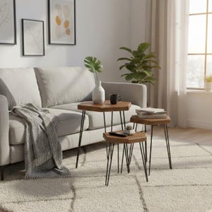 Può includere: Un set di tre tavolini a incastro esagonali in legno con sottili gambe a forcina in metallo nero. I tavoli sono disposti a gradoni, con un vaso in ceramica bianca, una tazza nera e una piccola pianta grassa posizionati sulle superfici.