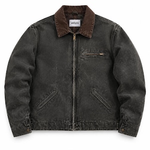 Op de afbeelding: Een antracietgrijze canvas jas met een donkerbruine corduroy kraag, een metalen ritssluiting over de gehele lengte en een kleine borstzak met rits. Het kledingstuk heeft twee schuine steekzakken en een wit label met de tekst velora.