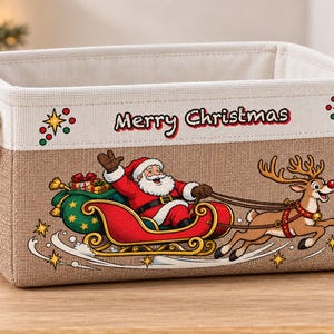 May include: A rectangular storage basket with a beige fabric exterior and white trim. The front features a printed graphic of Santa Claus in a red sleigh pulled by a reindeer, with the text Merry Christmas and decorative stars.