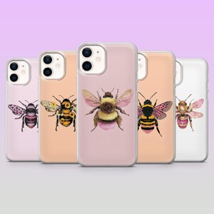 Peut inclure: Cinq coques de smartphone transparentes alignées, chacune présentant une illustration unique de bourdon. Les abeilles sont représentées avec divers détails artistiques, incluant des taches léopard roses, des tournesols et des textures duveteuses en jaune, noir et rose.